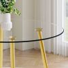 A modern minimalist style round transparent tempered glass table with gold metal legs